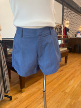 Load image into Gallery viewer, Chambray high-rise pleated shorts with flat front, belt loops, pockets, and a 3-inch inseam
