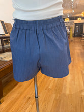 Load image into Gallery viewer, Chambray high-rise pleated shorts with flat front, belt loops, pockets, and a 3-inch inseam
